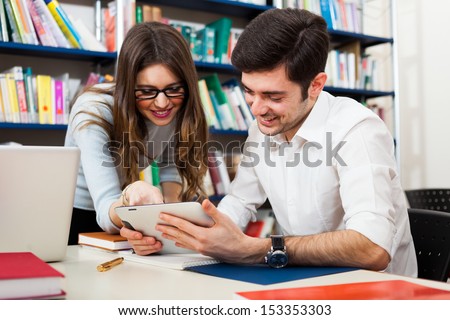 Students using a digital tablet in a library