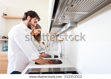 Young couple doing dishes in the kitchen