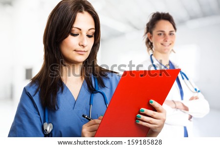 Portrait of a beautiful nurse writing on a case history