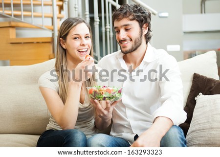 Woman eating a salad in the living room
