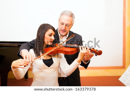 Violin teacher helping a student