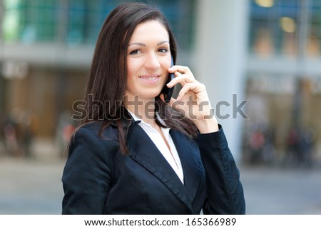 Young businesswoman at phone in an urban setting