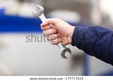 Man holding a wrench. Car servicing concept