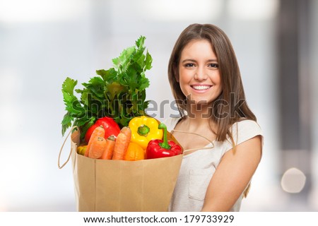 Woman holding a shopping bag full of fresh food