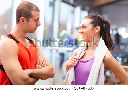 Personal trainer talking to a girl in a fitness club