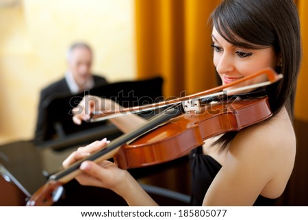 Female violinist and male pianist playing together