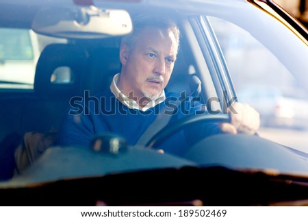 Bored mature man driving his car