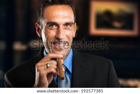 Mature businessman smoking a cigar in a classy room