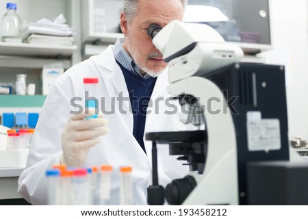 Man using a microscope in a chemical laboratory