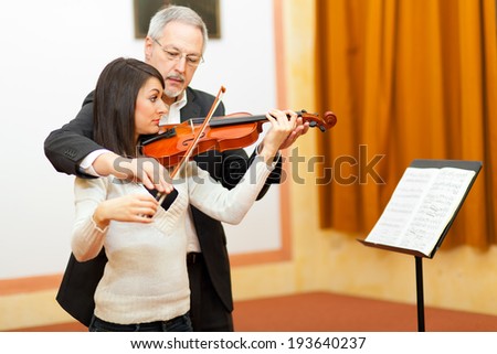 Violin teacher helping a student at the conservatory