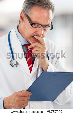 Senior doctor reading a case history