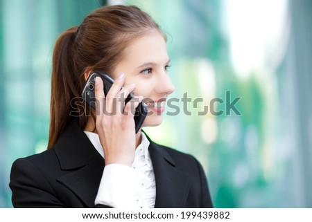 Smiling businesswoman talking on the phone in an urban setting
