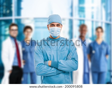 Portrait of a confident surgeon in front of a group of doctors