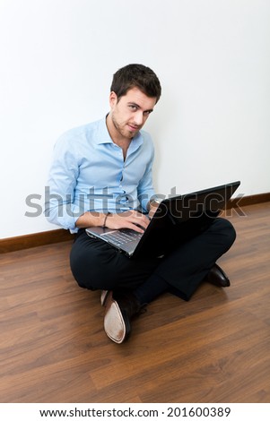 Young man sitting on the floor with his laptop