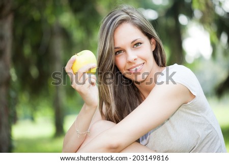 Woman eating an apple in the park