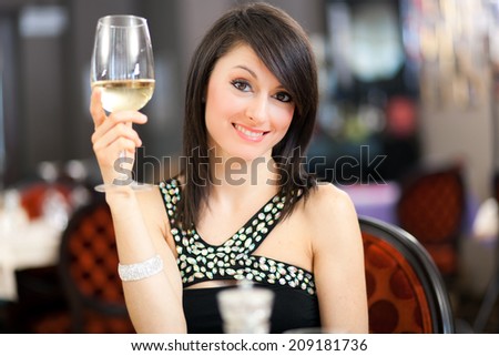 Beautiful woman tasting wine in a restaurant