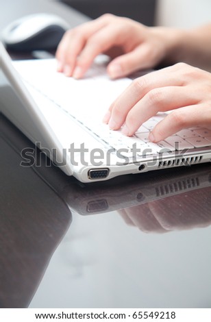 Closeup of female hands typing on a laptop in the office