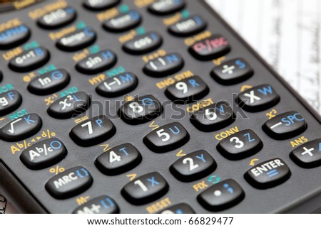 Black scientific calculator keypad closeup on a notebook