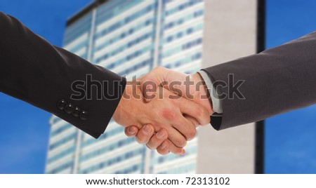 Handshake against a blurred skyline background