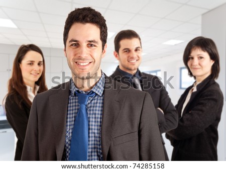 A group of businessmen and businesswomen in an office environment, their leader is on the front