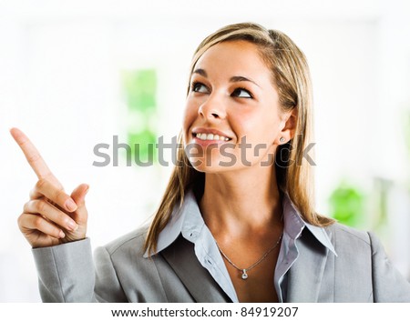 Portrait of a young businesswoman pointing her finger up