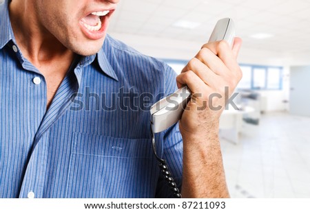 Angry businessman screaming at the phone