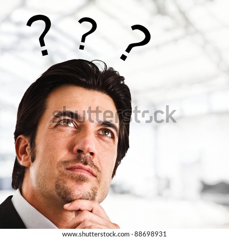 Portrait of a thoughtful man with question marks surrounding his head