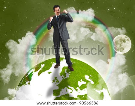 Happy businessman raising his arms on the top of a green earth