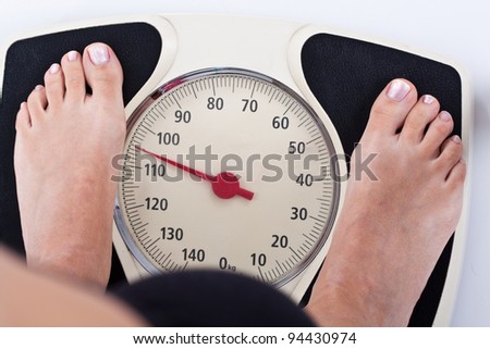 Woman measuring her weight on a balance