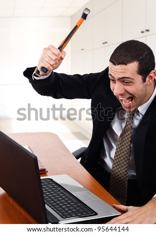 Angry worker smashing his laptop
