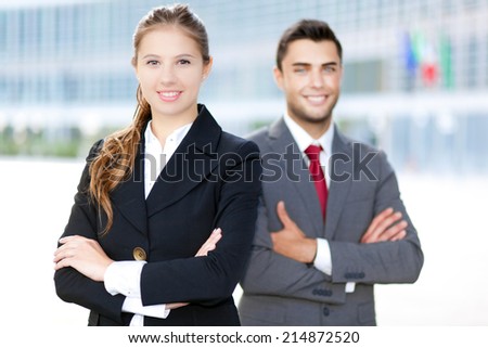 Two business people smiling in an urban setting