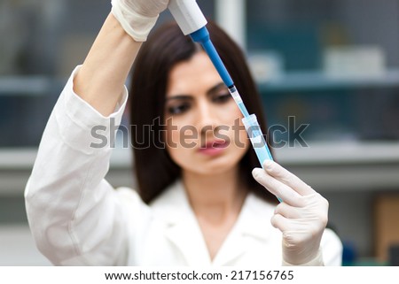 Female researcher analyzing a test tube