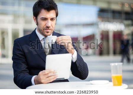 Businessman reading his digital tablet during breakfast