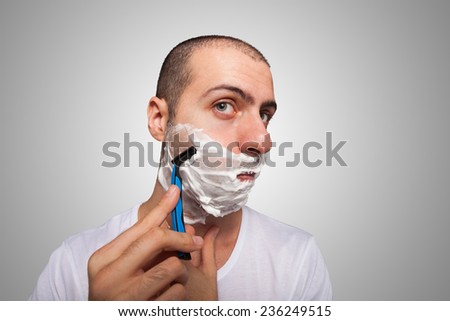Man using a disposable razor to shave his beard off