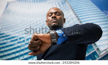 Handsome businessman looking at his watch