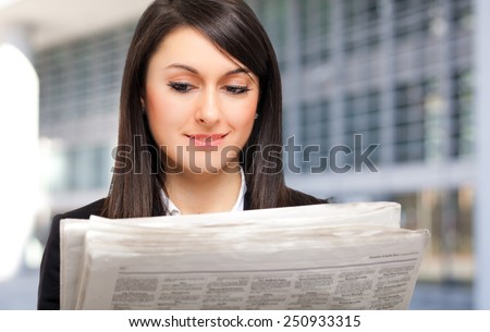 Beautiful woman reading the newspaper outdoor