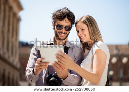 Couple of tourists using a digital tablet