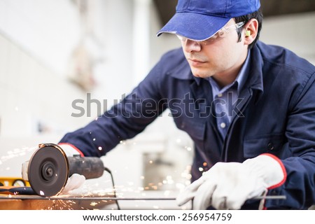 Portrait of a worker using a grinding machine to cut a metal plate