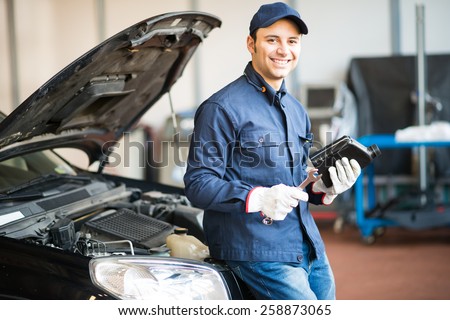 Portrait of an auto mechanic holding a jug of motor oil
