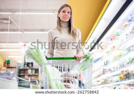 Woman pushing a shopping cart in a grocery store