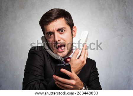 Stressed businessman talking on many phones at once