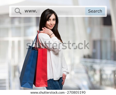 Young woman holding shopping bags in front of a search bar. Ecommerce concept