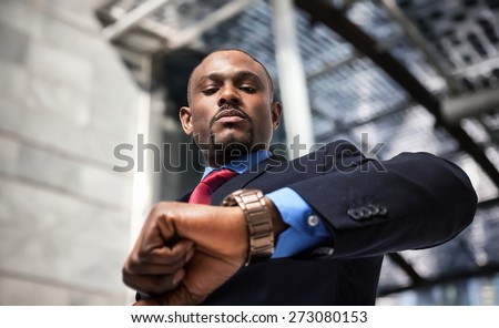 Handsome businessman looking at his watch