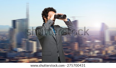 Businessman in search for opportunities on the top of a skyscraper