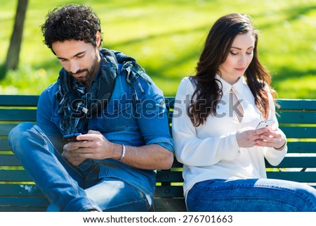 Couple not talking to each other typing on mobile phones