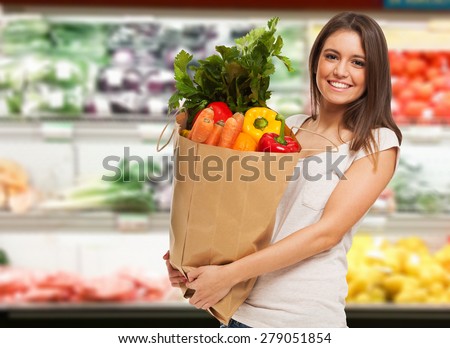 Smiling woman shopping in a supermarket