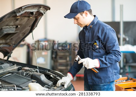 Portrait of a mechanic holding a wrench in his garage