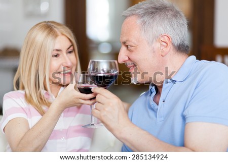 Mature couple toasting wine glasses