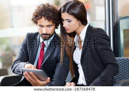 Two business people using a digital tablet