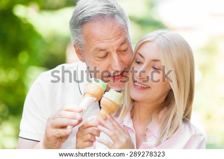 Senior couple eating an ice cream outdoor
